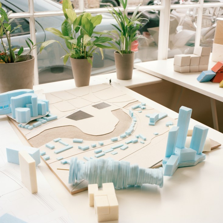 Architectural models and building components for a Southeast Asia development project displayed on a studio desk.