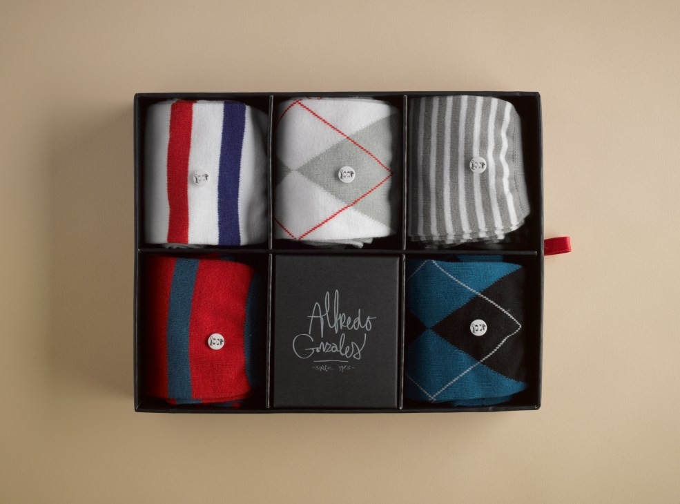 Alfredo Gonzales sock collection displayed in a black presentation box with six compartments showing colorful patterned socks.