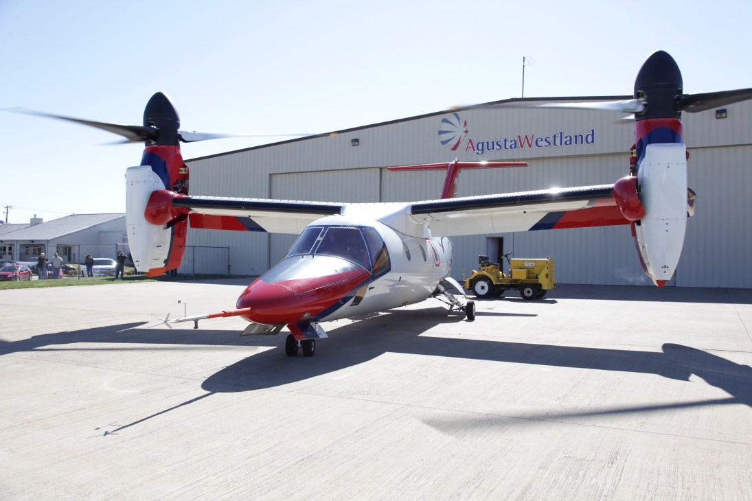 AgustaWestland AW609 tiltrotor aircraft with red and white livery on an airport tarmac.