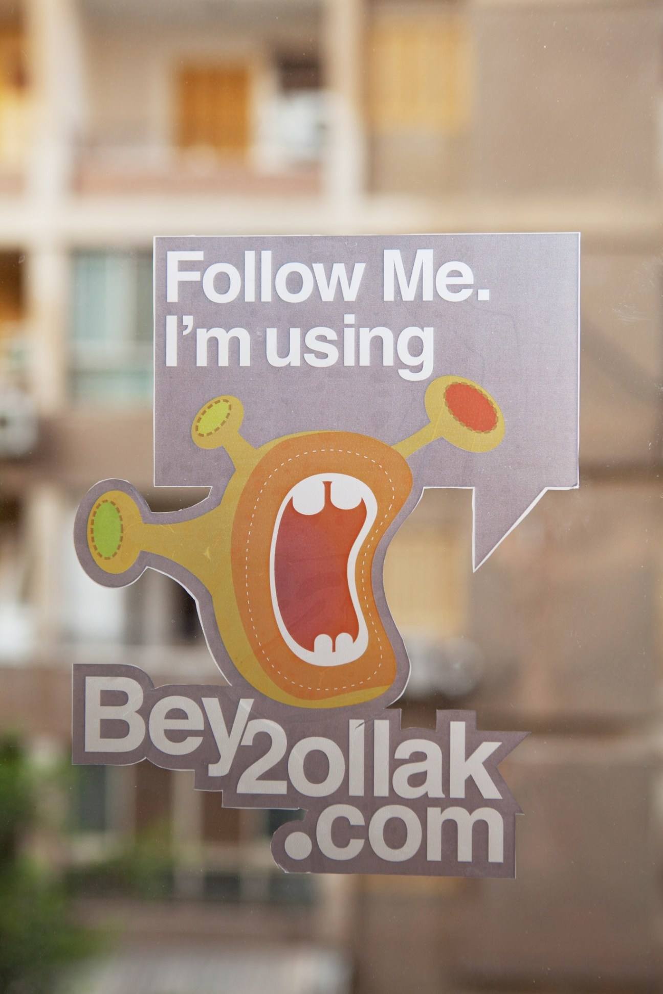 Bey2ollak traffic app promotional sticker with mascot character and website URL.