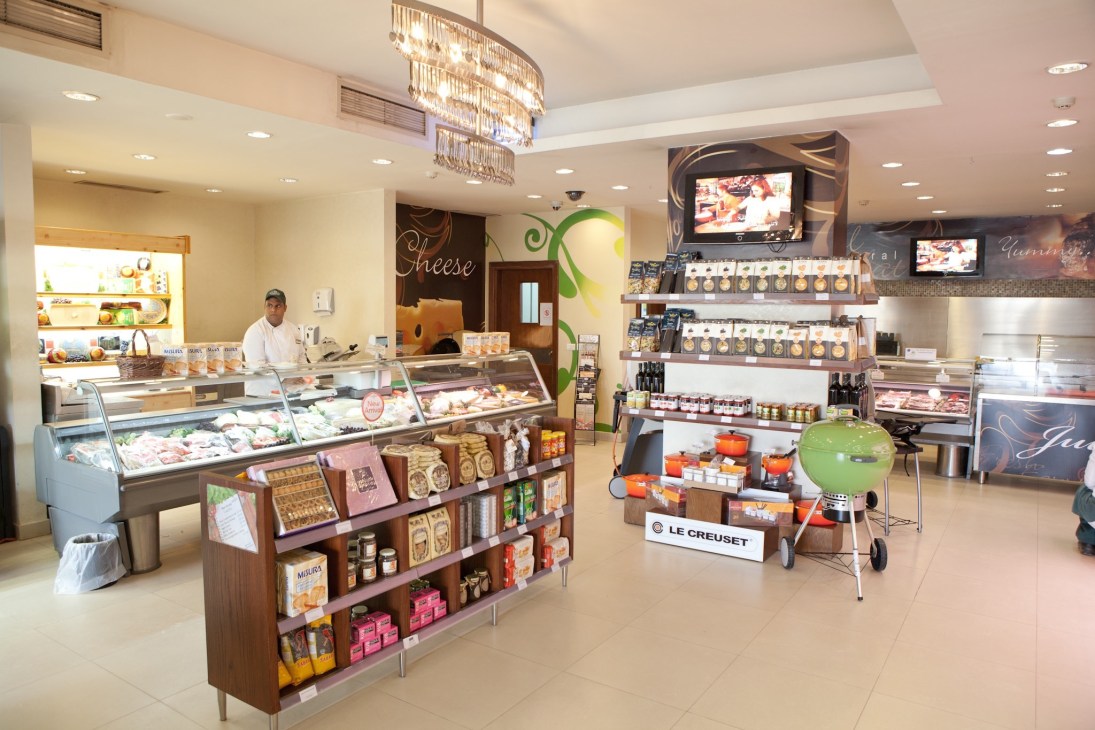 Interior of Gourmet Egypt gourmet food store with display cases, shelving, and staff member.