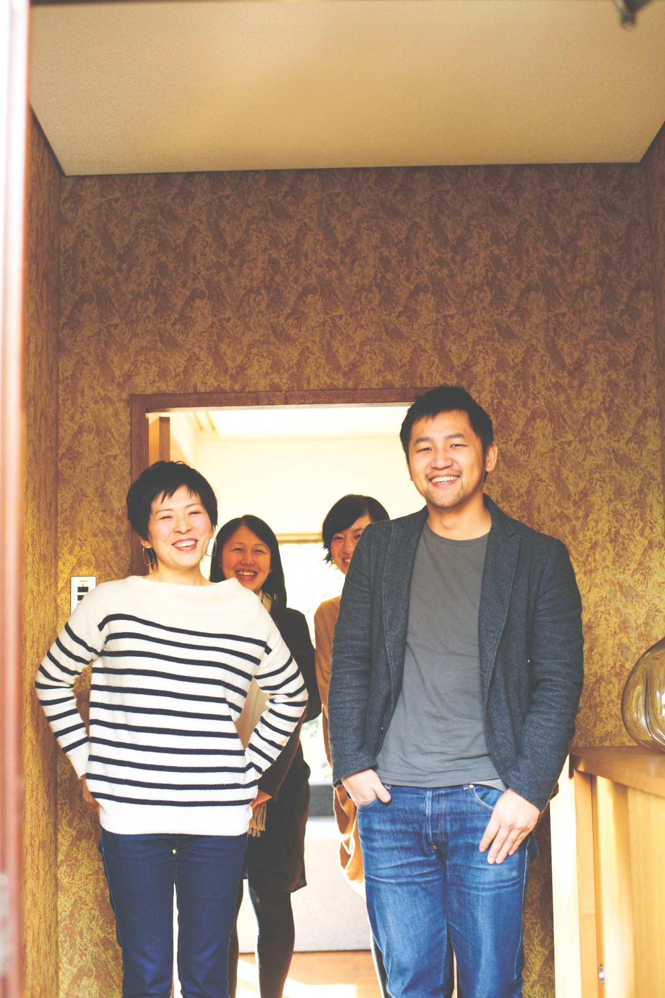 Teruhiro Yanagihara and staff members smiling at the entrance of his Kyoto design studio.
