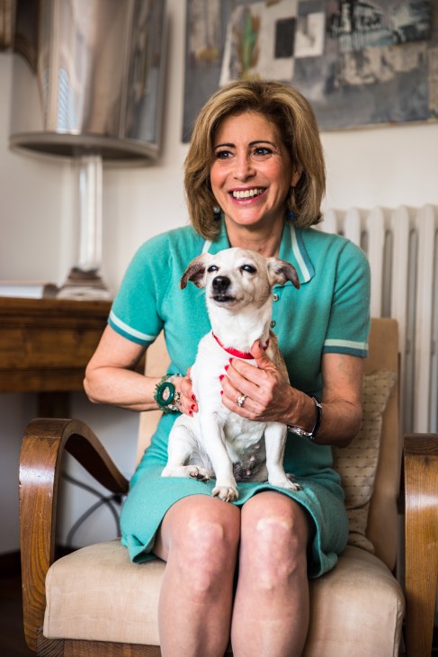 Simonetta Guidotti smiles while holding one of her Jack Russell dogs in her modernist apartment.