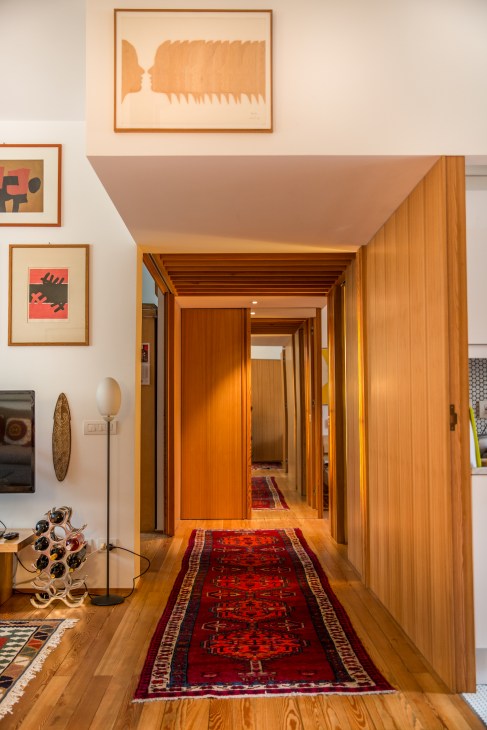 Corridor with Italian larch wood paneling and doors leading deeper into Gabriella Piga's apartment.