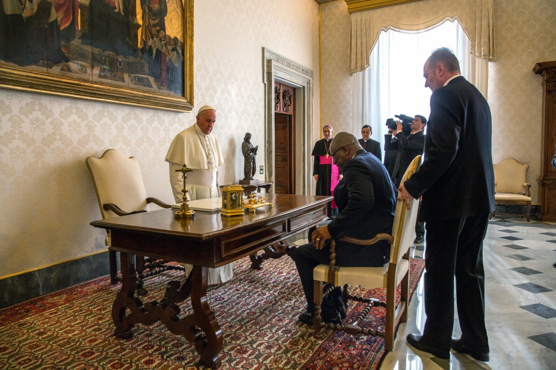 Pope Francis in white cassock welcomes Sir Rodney Williams, governor-general of Antigua and Barbuda, in an ornate Vatican reception room.