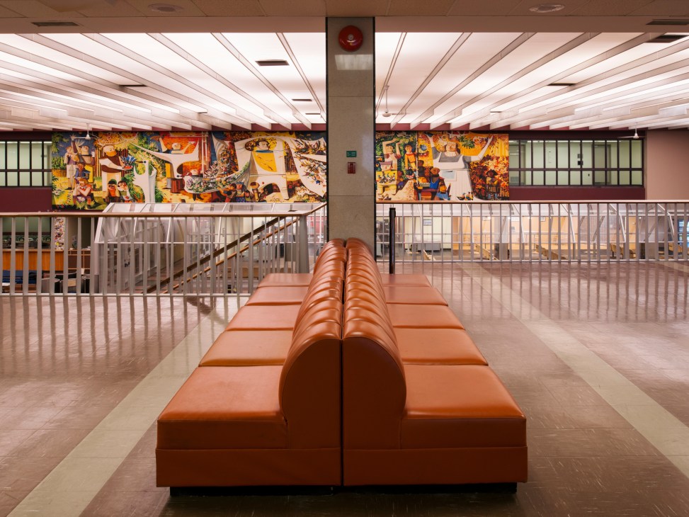 Mezzanine level at Gander International Airport with orange seating and Kenneth Lochhead's colorful mural visible above.