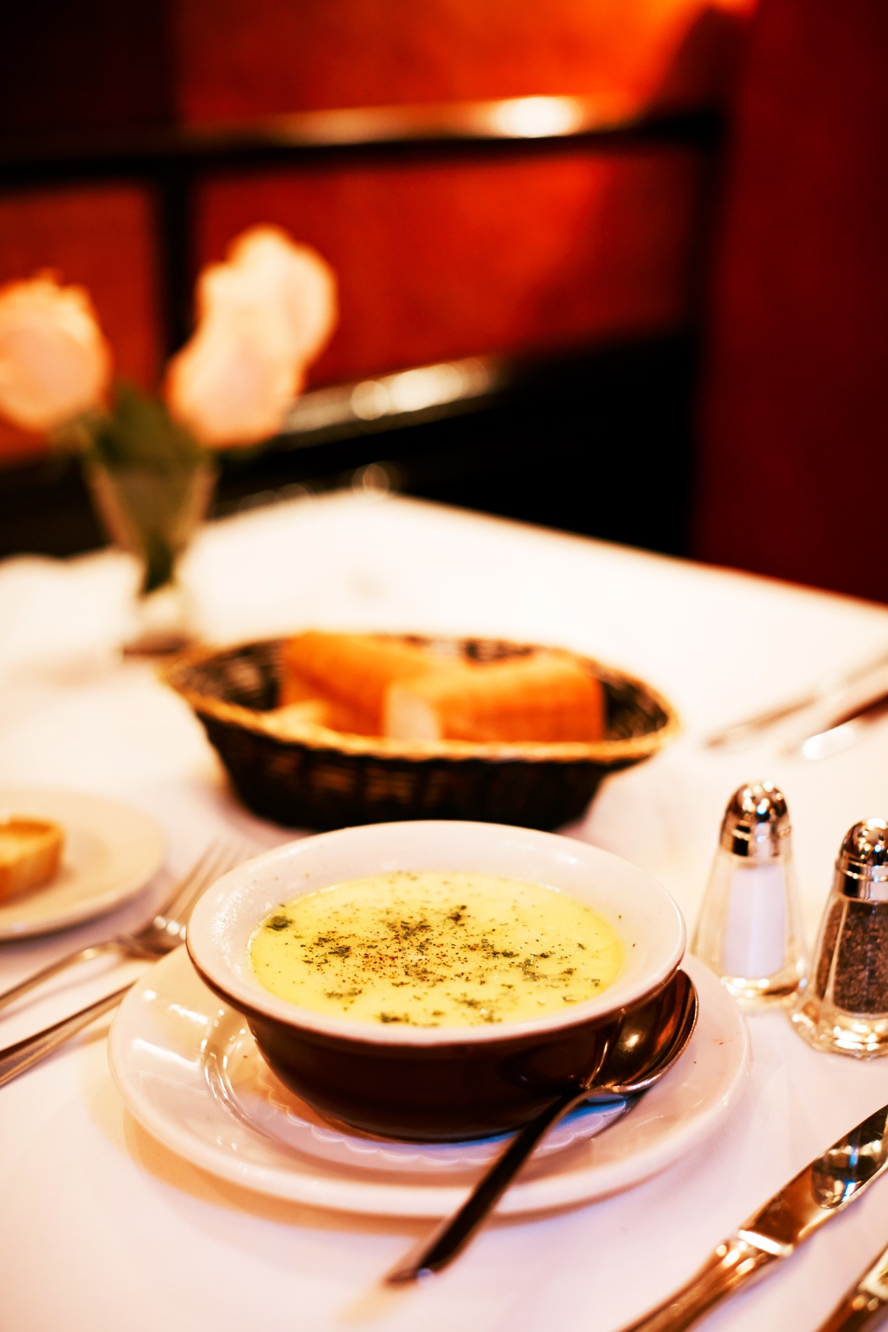 Mussel soup with herbs served in a black bowl at Le Veau d'Or restaurant.