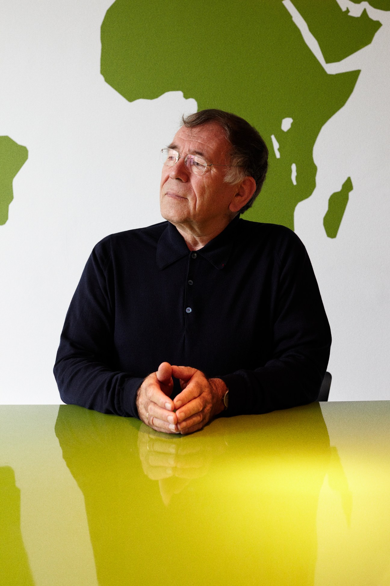 Jan Gehl sits at a yellow table in his Copenhagen office with a green map of Africa behind him.