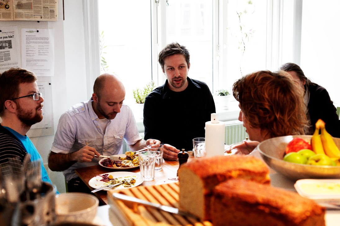 Gehl Architects staff members eating lunch together at a table with organic food and beverages.
