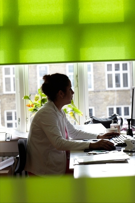 Aimee Hansen, accountant at Gehl Architects, sits at her desk working on a computer.