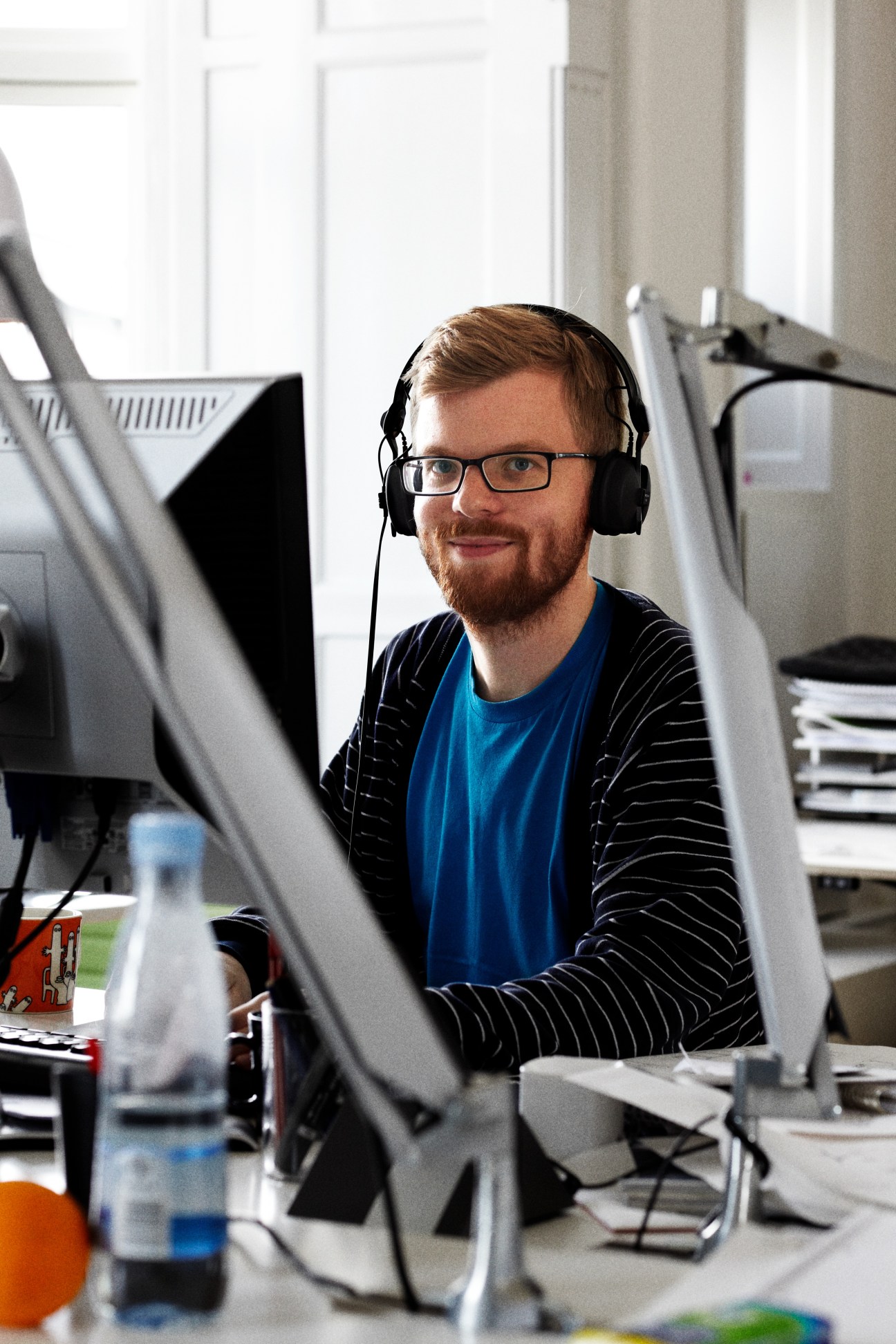 Fredrik Garpenfeldt, urban designer at Gehl Architects, wearing headphones at his desk in the Copenhagen office.