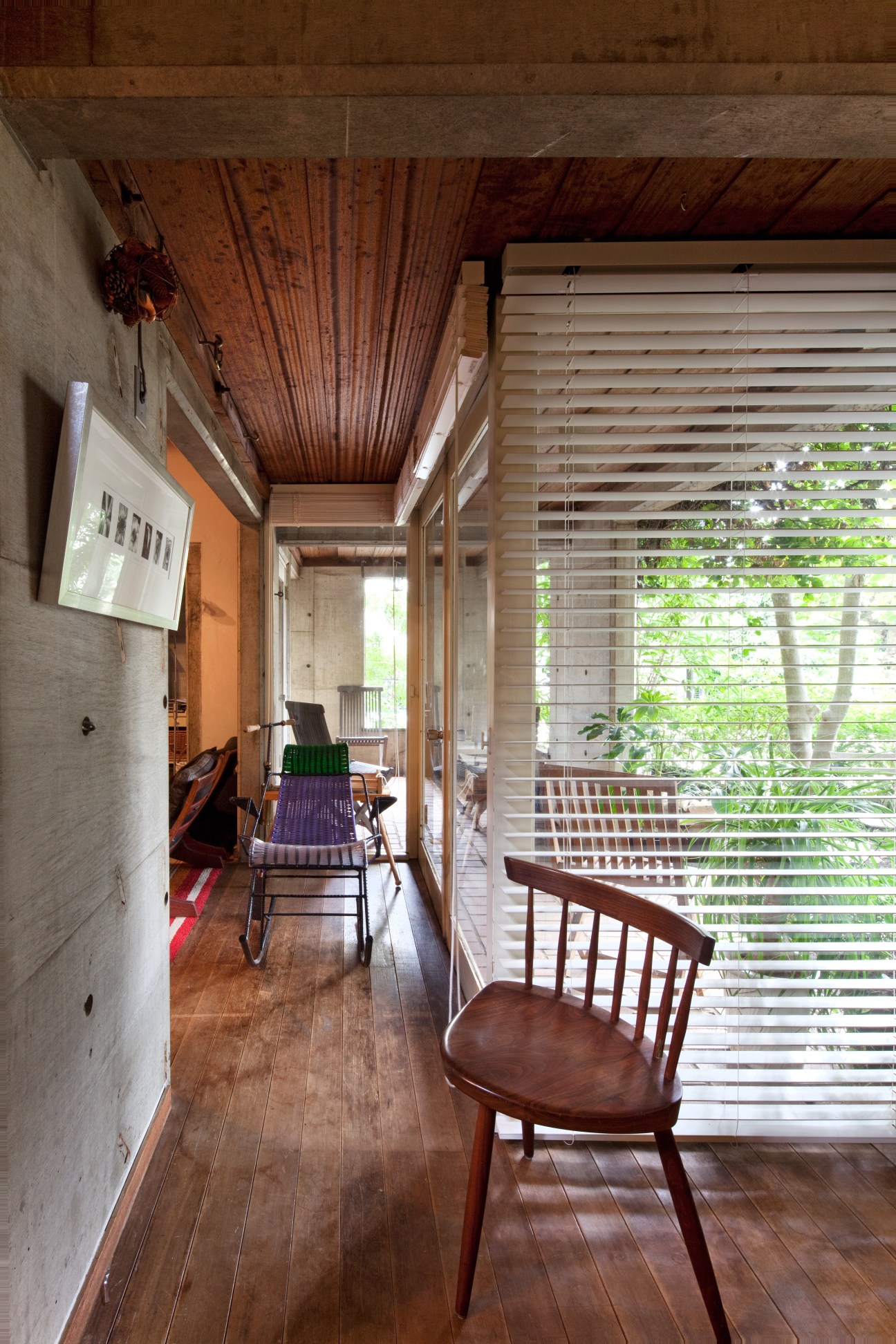 Mira chair by George Nakashima in interior hallway with wooden ceiling and window blinds