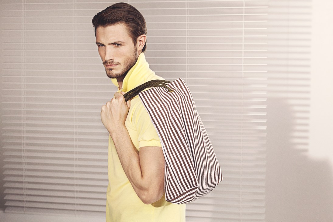 Man wearing yellow shirt carrying striped cotton canvas tote bag with rope handles designed by Pool Madrid.