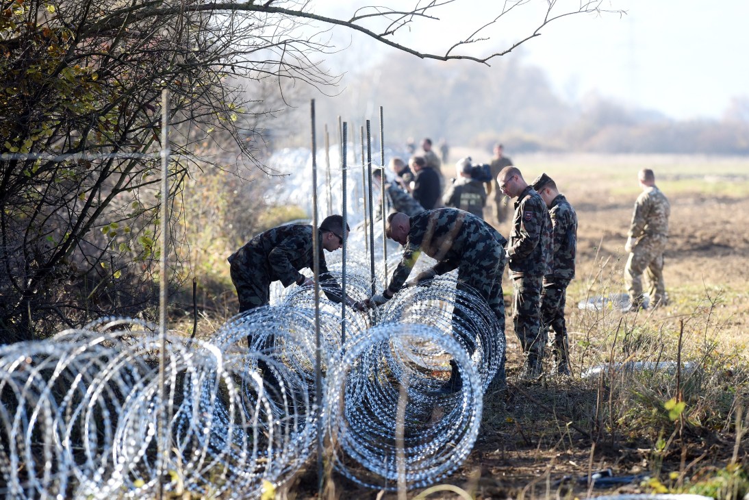 Slovenian soldiers laying barbed wire across the Slovenian-Croatian border near Rakovec.