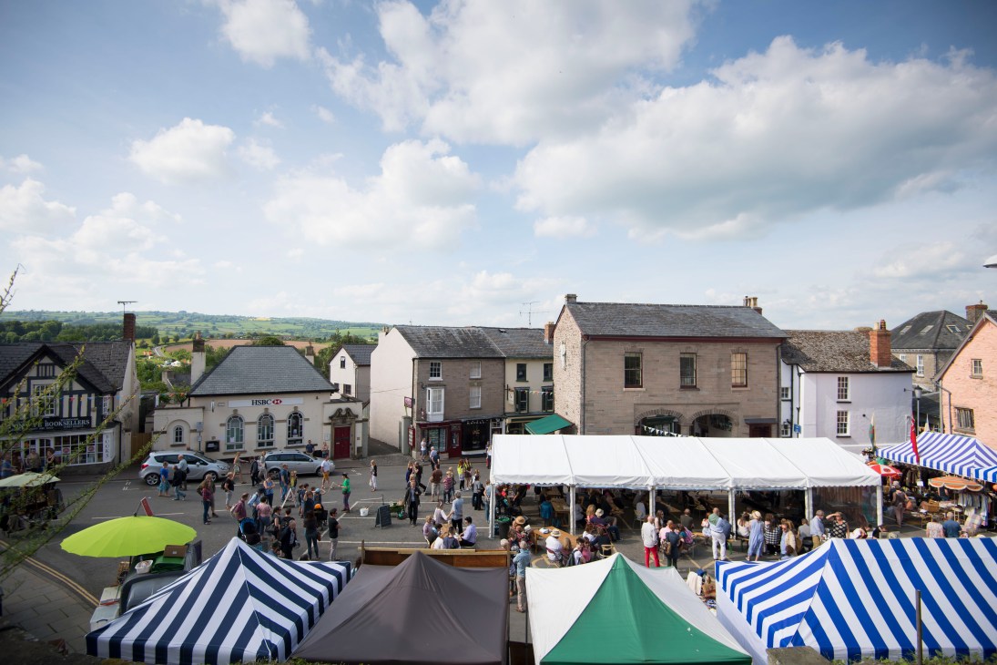 Aerial view of Hay-on-Wye town centre with festival tents, striped marquees, and crowds during the 2016 festival.
