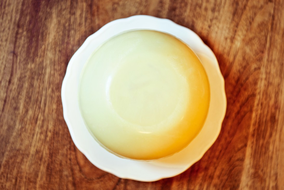 White-chocolate dome with orange blossom rice pudding centre served in a bowl.