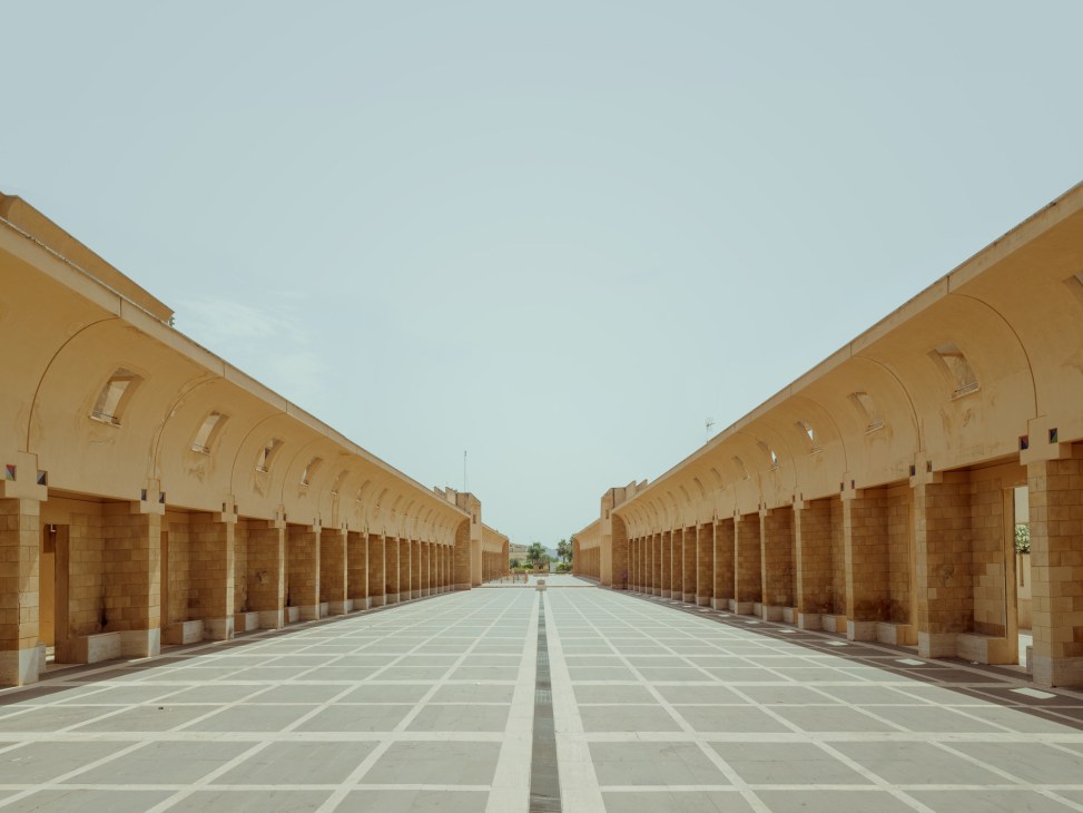 Symmetrical colonnade corridor with arched ceilings and geometric paving by Franco Purini and Laura Thermes