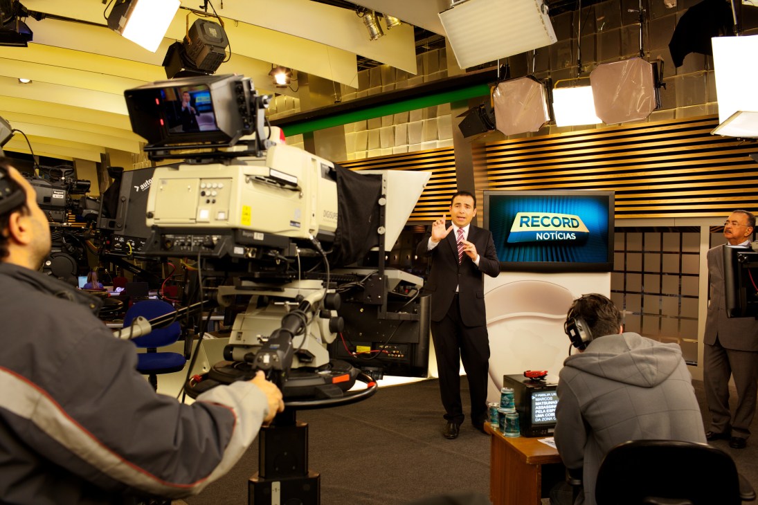 Record news broadcast studio with anchor presenting live news with professional camera crew and lighting equipment