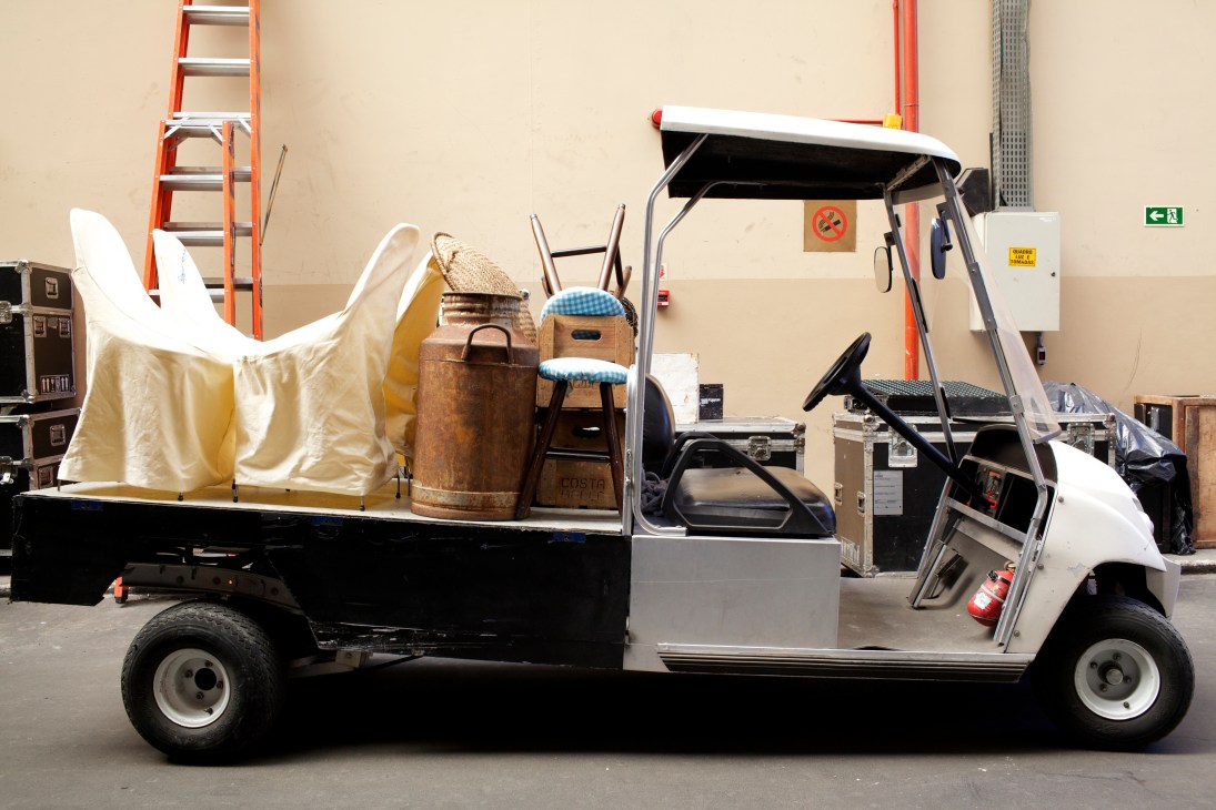 Golf buggy loaded with vintage props and furniture on Globo's Projac soundstage lot.