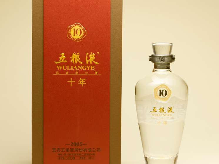 Wuliangye bai jiu bottle with red and gold packaging box and clear glass bottle with metal collar