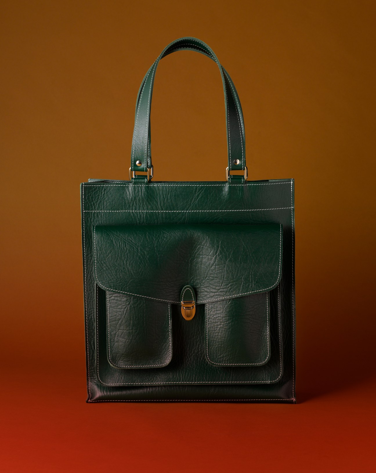 Dark green leather schoolbag with metal clasp and contrast stitching, Piet Breinholm design.