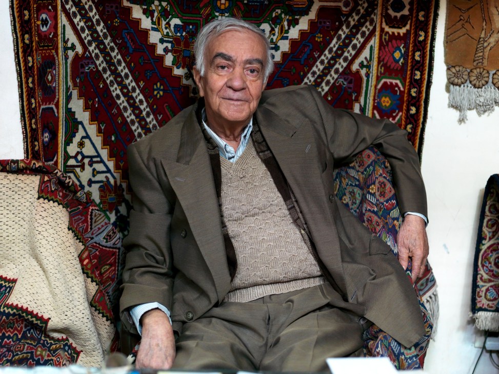 Hossein Soleimani, 87, sits among Persian carpets in his Tehran bazaar shop.