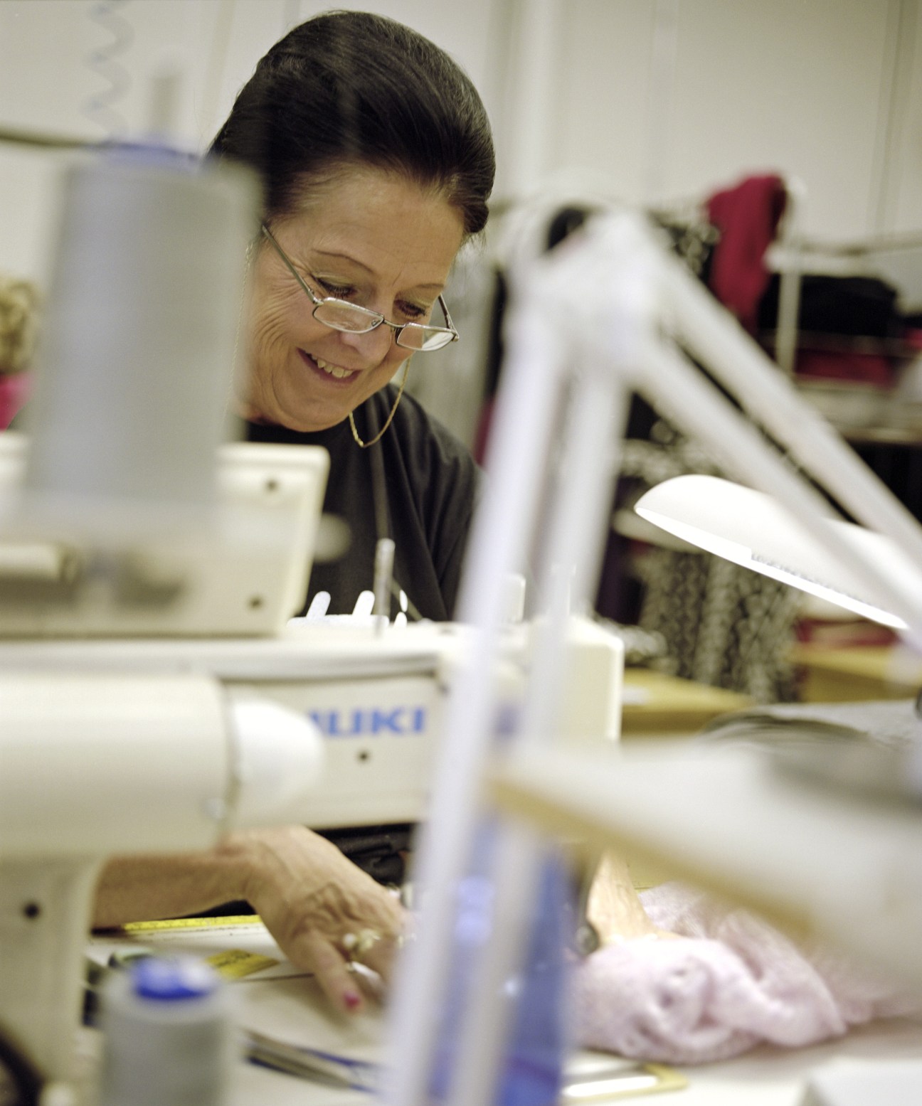 A factory worker at a sewing machine in the Tuusula knitting factory used by Hanna Sarén.