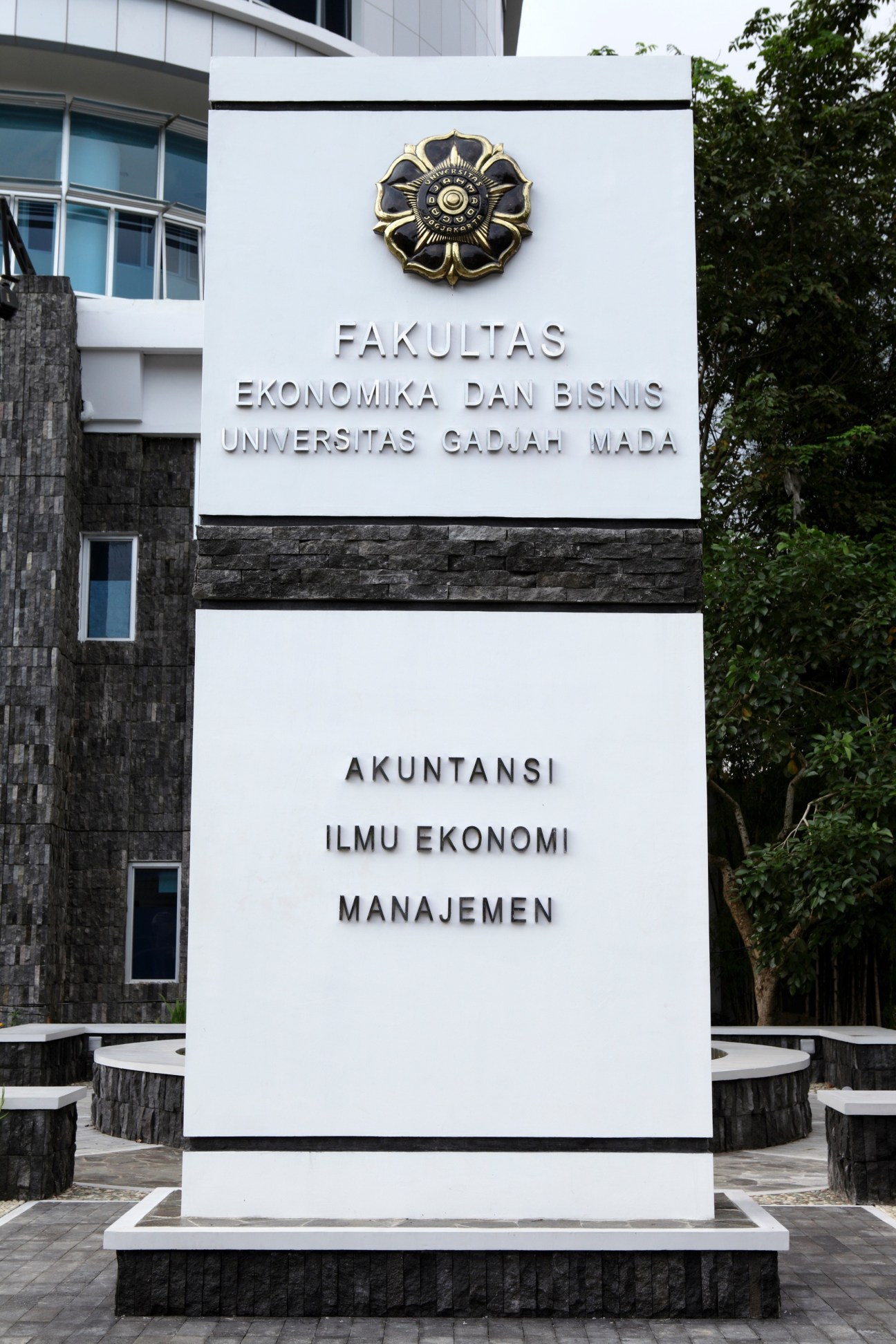 Entrance sign to the economics faculty at Gadjah Mada University in Yogyakarta with decorative emblem.