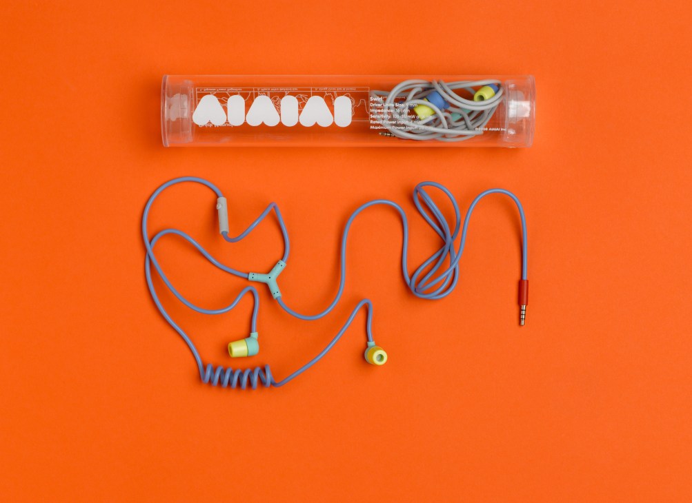 Aiaiai Y-Com blue earphones with yellow earbuds and packaging on orange background.