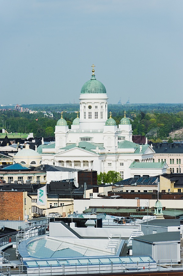 Helsinki Cathedral with white neoclassical architecture and green copper dome overlooking the city skyline.