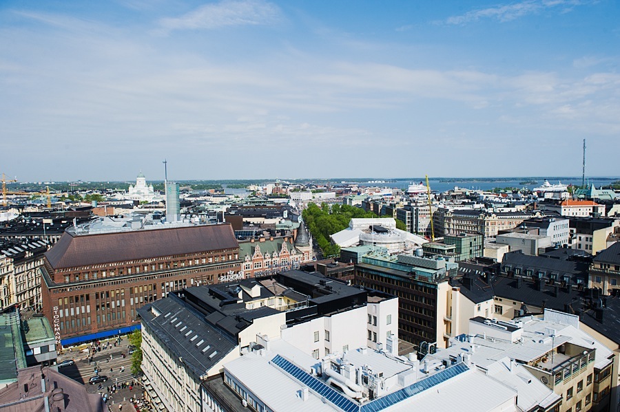 Aerial view of Helsinki's cityscape showing historic and modern buildings with waterfront in distance.