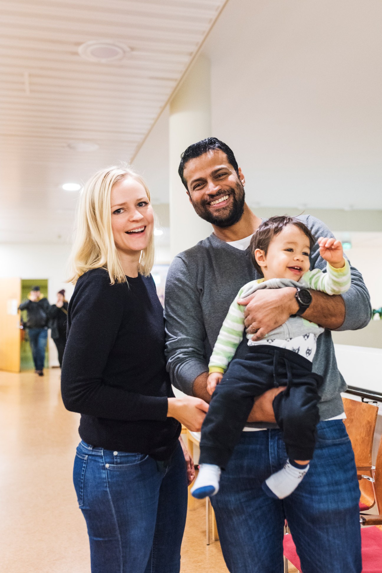 Karla and Richard Jerome smile while holding their toddler son Arthur at a child-health clinic.