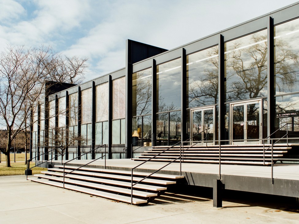 SR Crown Hall exterior with glass facade, black steel frame, wide steps and bare trees at IIT.
