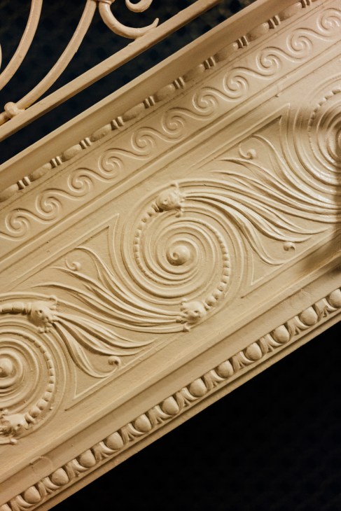 Ornate cream-colored decorative molding with scrolled and circular relief patterns on the Old Colony Building's staircase.
