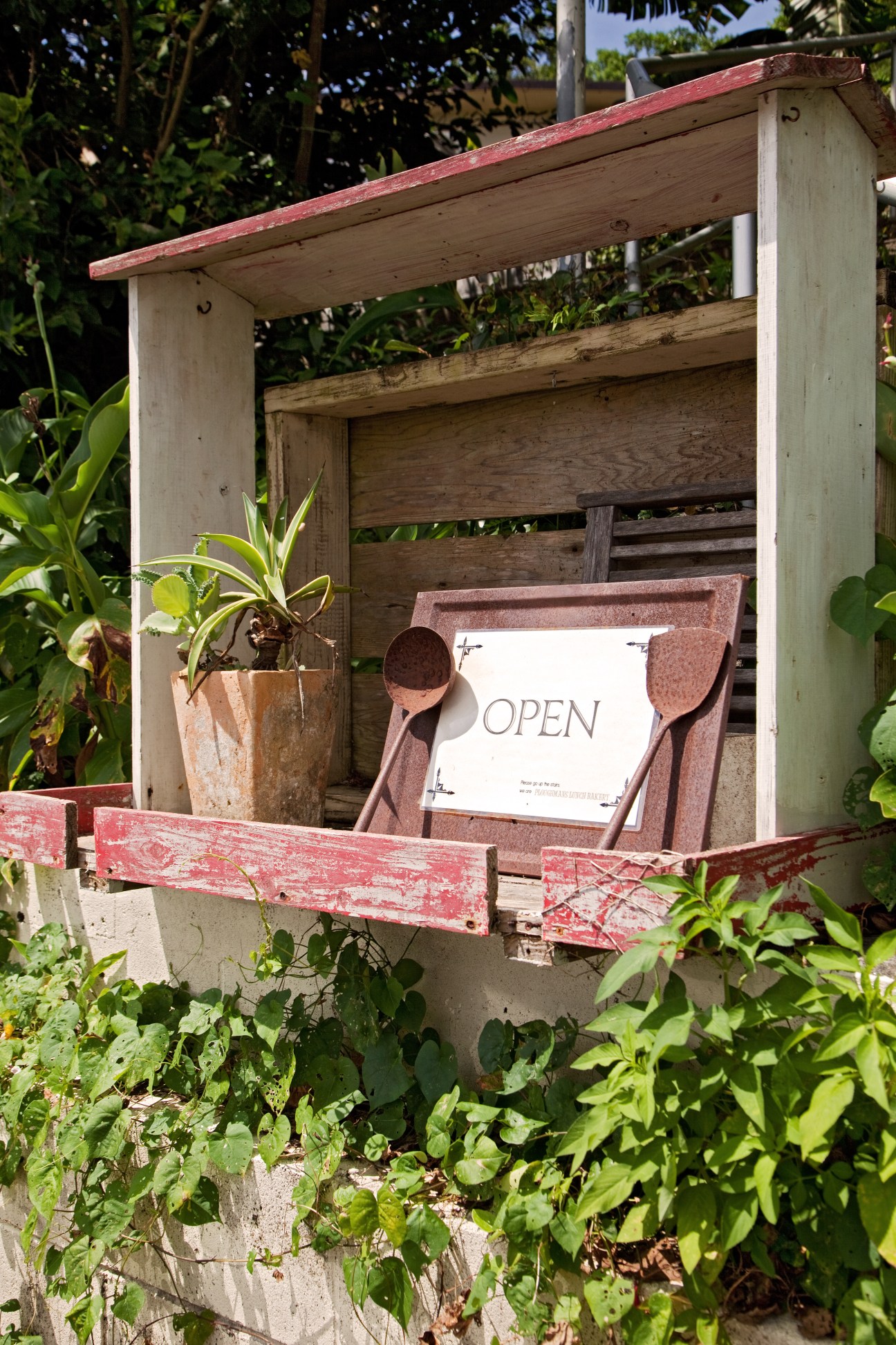 Rustic wooden roasting room with red-trimmed roof and an open sign displayed on the storefront.