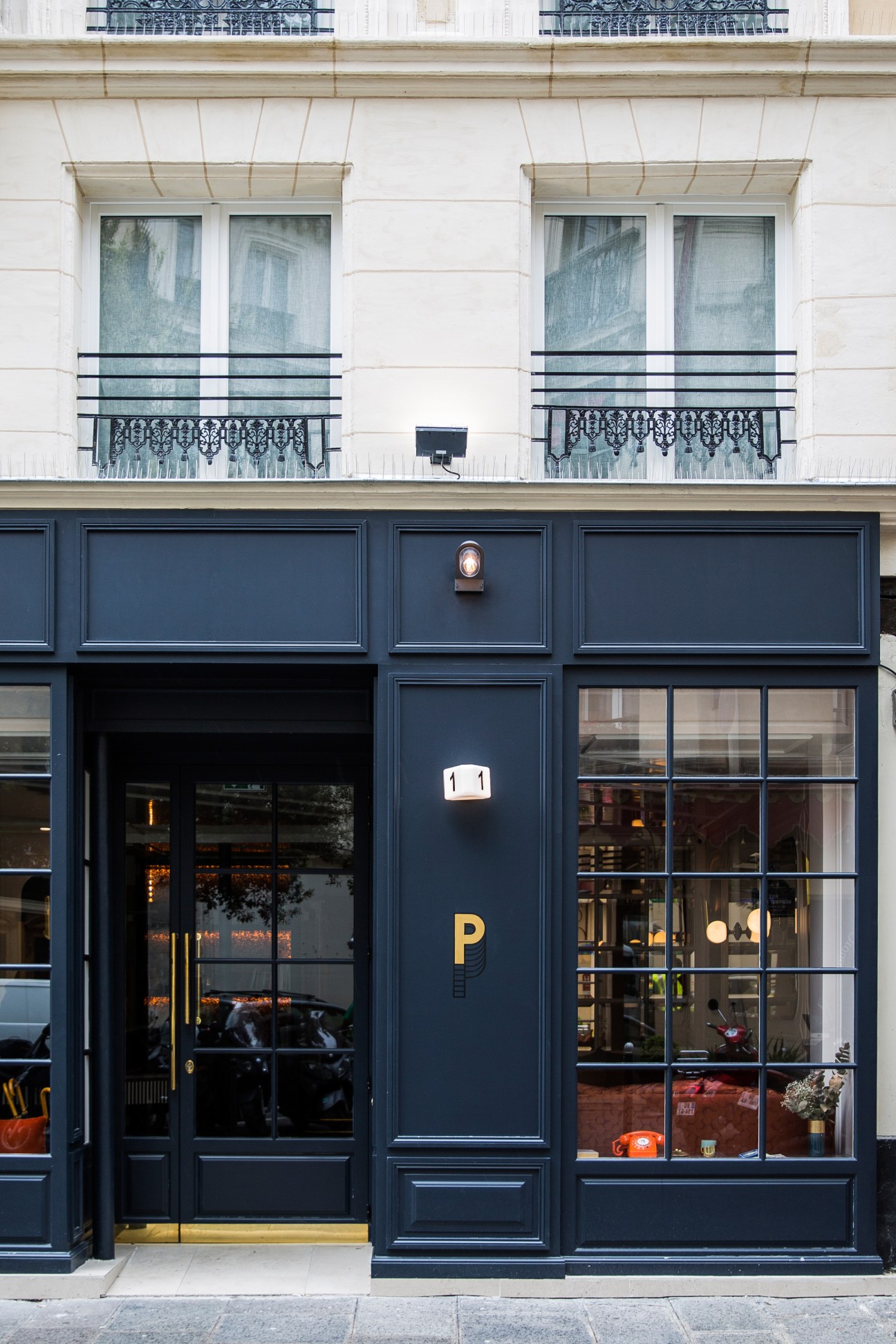 Hotel Panache storefront in Paris with dark blue facade, gold lettering and number 11 above the entrance.