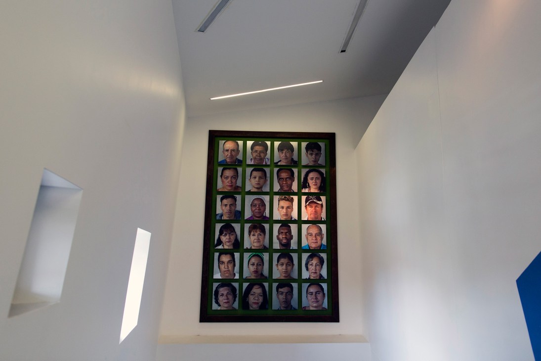 Grid of 24 portrait photographs of individuals commemorating victims of Colombia's civil war conflict.