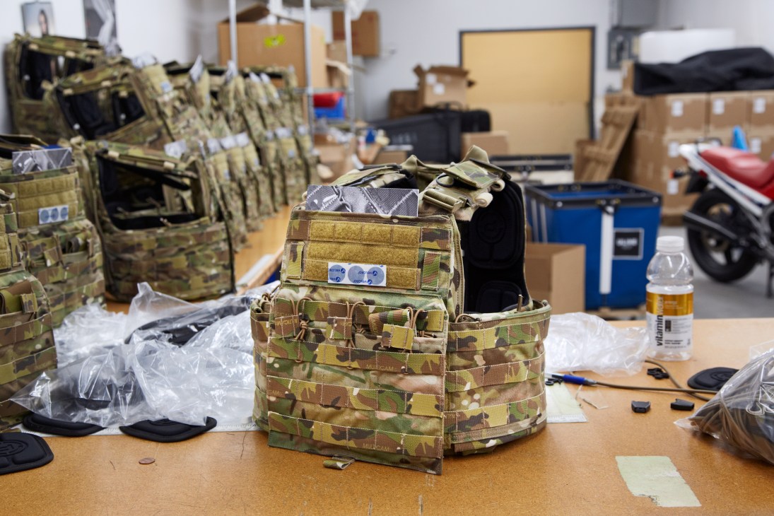 CAGE Armor Chassis armoured vest in MultiCam pattern displayed on workbench during final production stage.