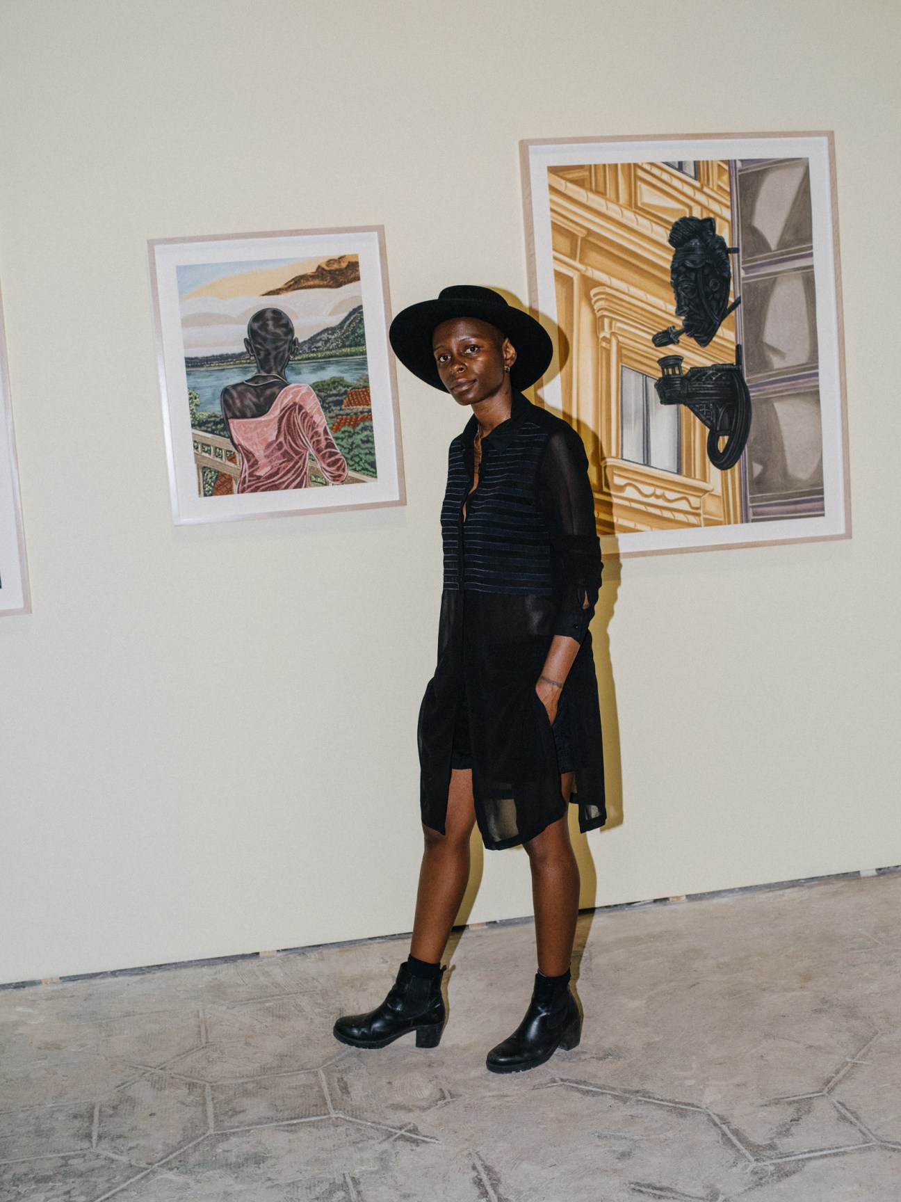 Nigerian-American artist Toyin Ojih Odutola standing beside her framed pastel and chalk drawings at the Orto Botanico