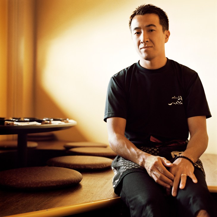 Masayuki Kobayashi sits at a wooden table at Miyabi restaurant in Honolulu.