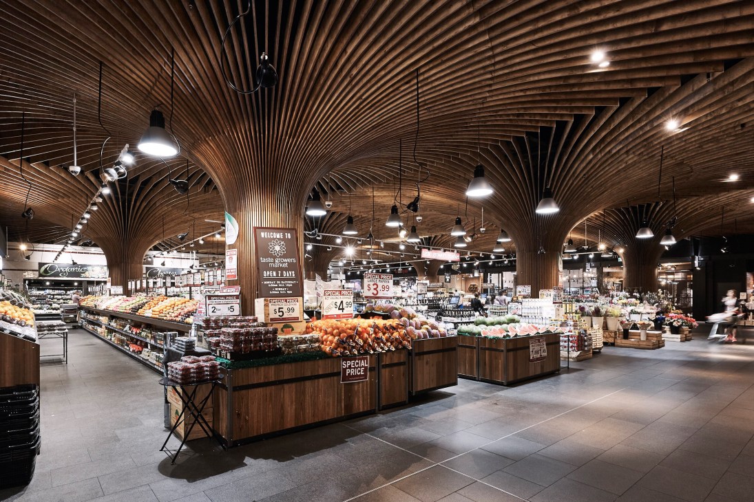 Modern grocery store with dramatic curved wooden ceiling and produce displays in wooden fixtures