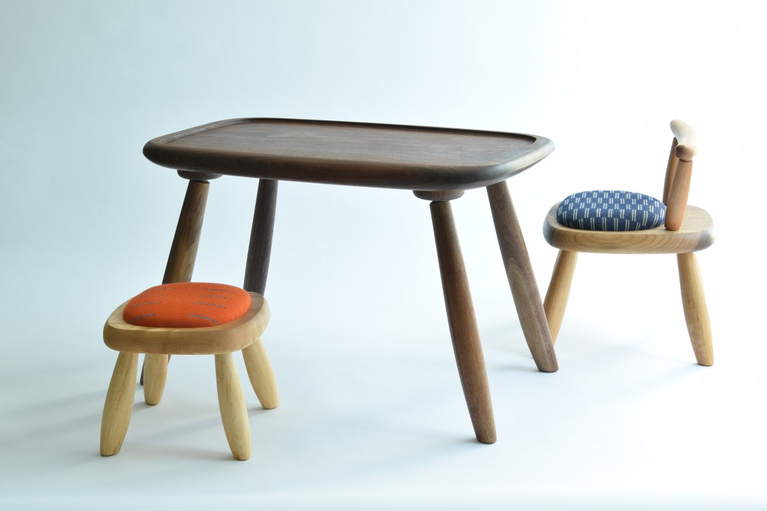 Sfera kids collection table with two wooden chairs with upholstered seats in orange and blue patterns.
