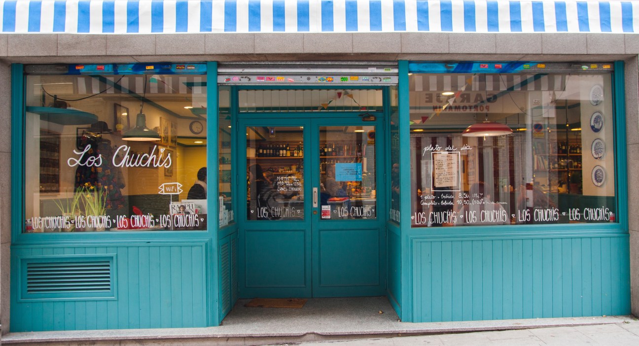 Los Chuchis restaurant storefront with turquoise doors and windows in Madrid's Lavapies neighbourhood.