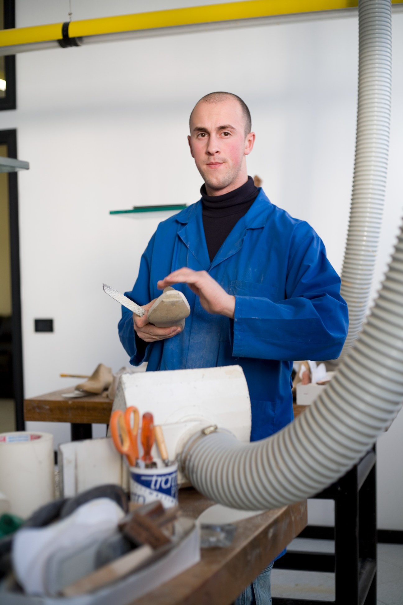 Trainee Lorenzo Angeletti carves a wooden shoe last in a workshop at Formificio Veregra.