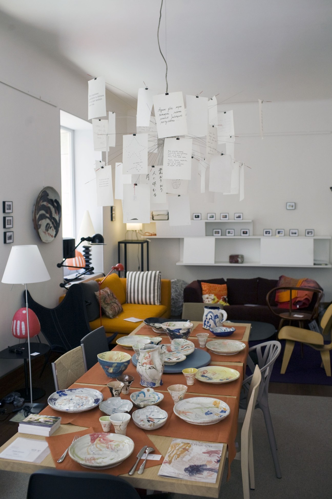 Interior of Le Rond dans l'Eau furniture shop with dining table set and modern hanging light fixture.