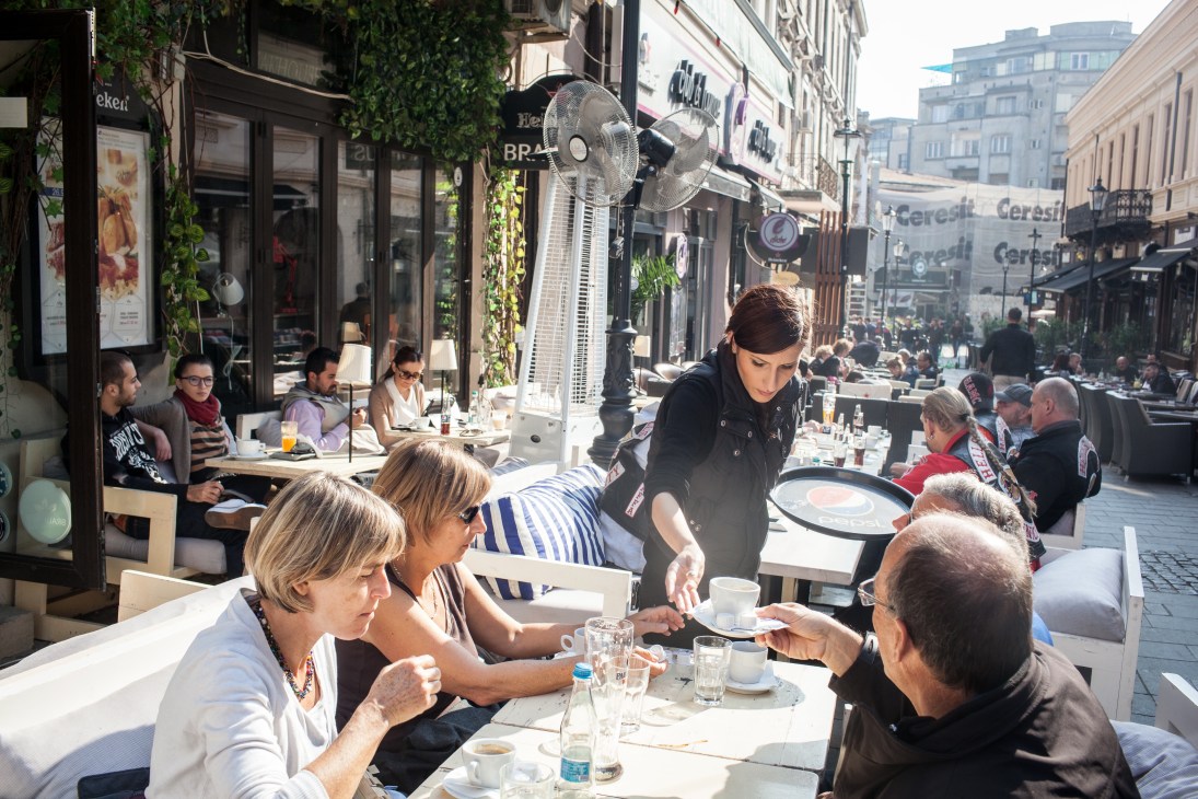 Outdoor café on Smardan Street in Bucharest's Old City with diners and waitstaff.