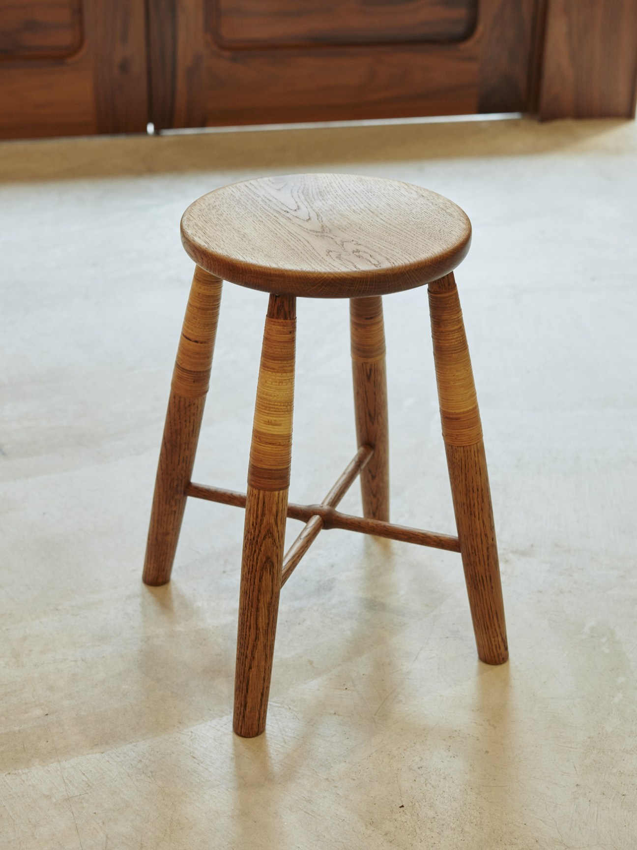 Wooden stool with round seat and four tapered legs by Tomokazu Sakurai.