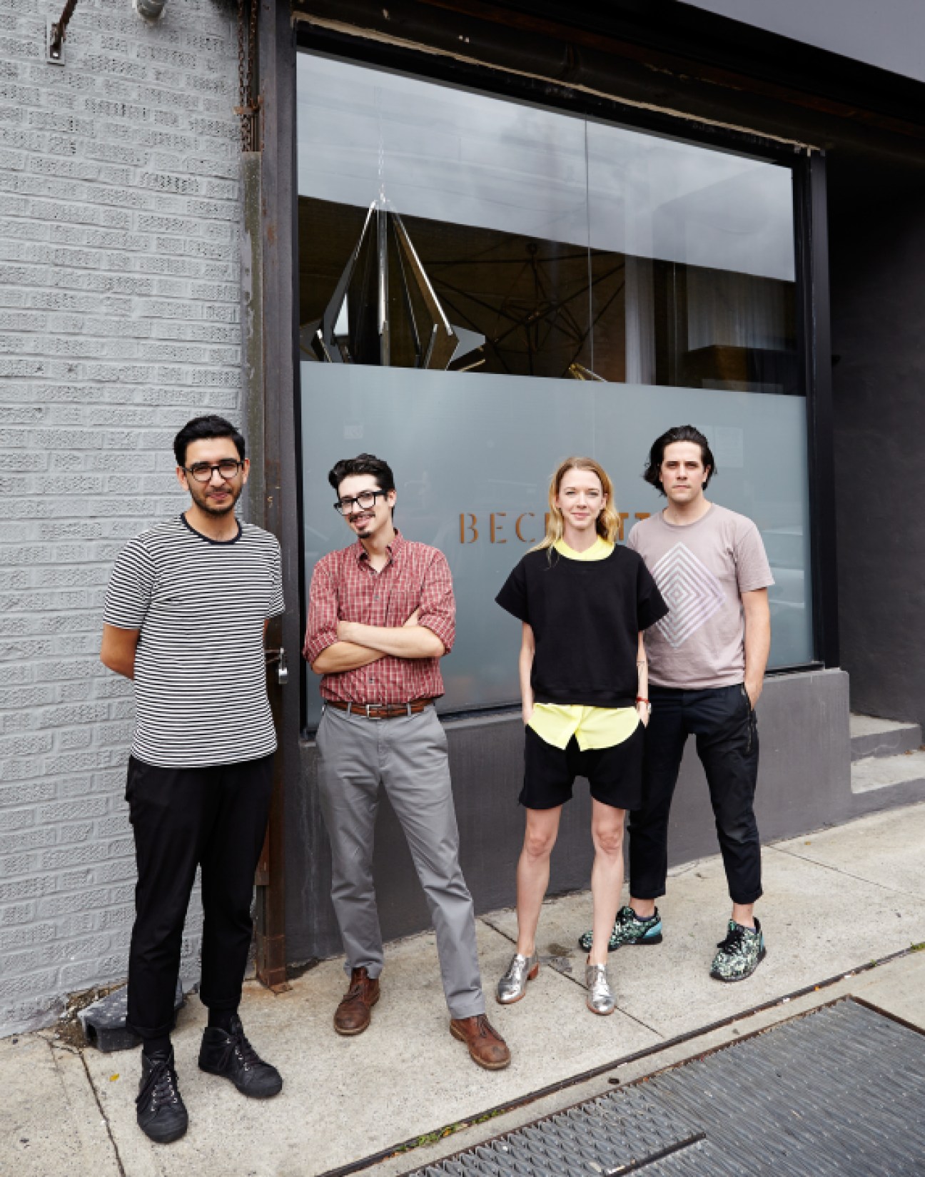 Bec Brittain stands third from left with three male employees outside her Brooklyn studio storefront.