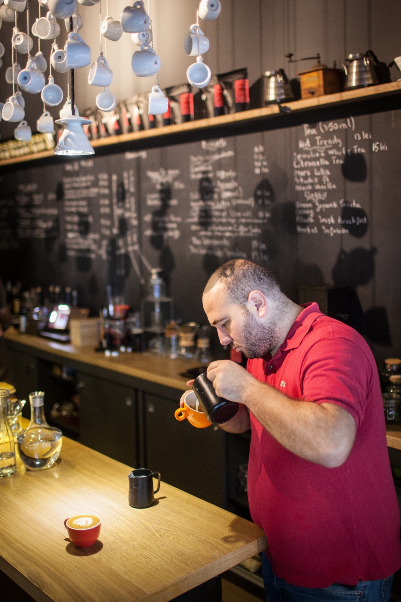 Mihai Panfil, barista, steams milk at the counter of his café Origo in Bucharest.