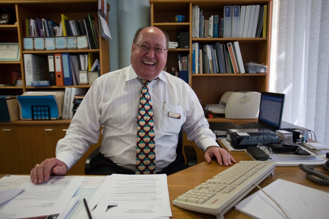 Chris Young, CEO of the Northern Territory Chamber of Commerce, smiling at his desk wearing a white shirt and South Park tie.